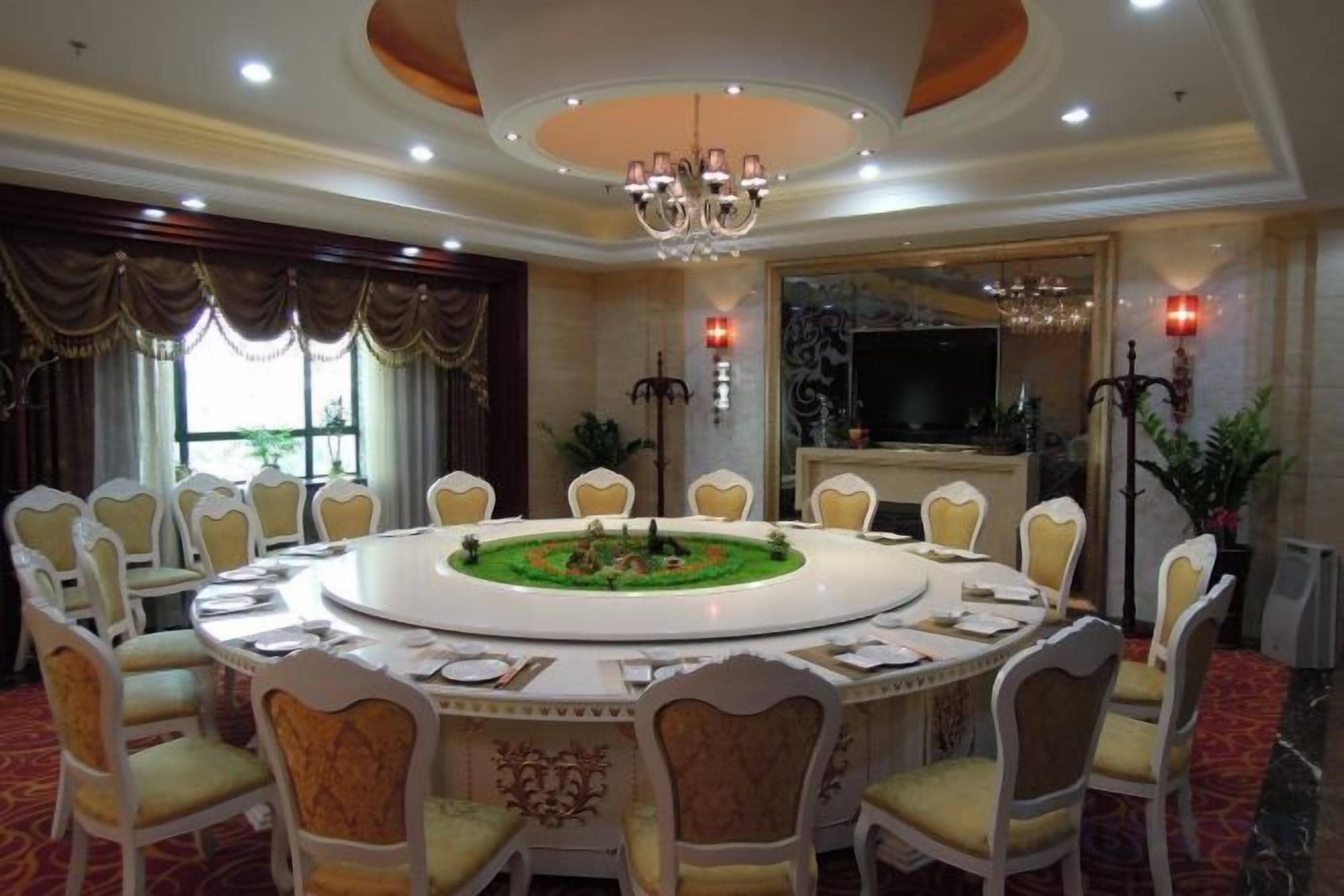 A conference room with a round table, chairs, and a chandelier.