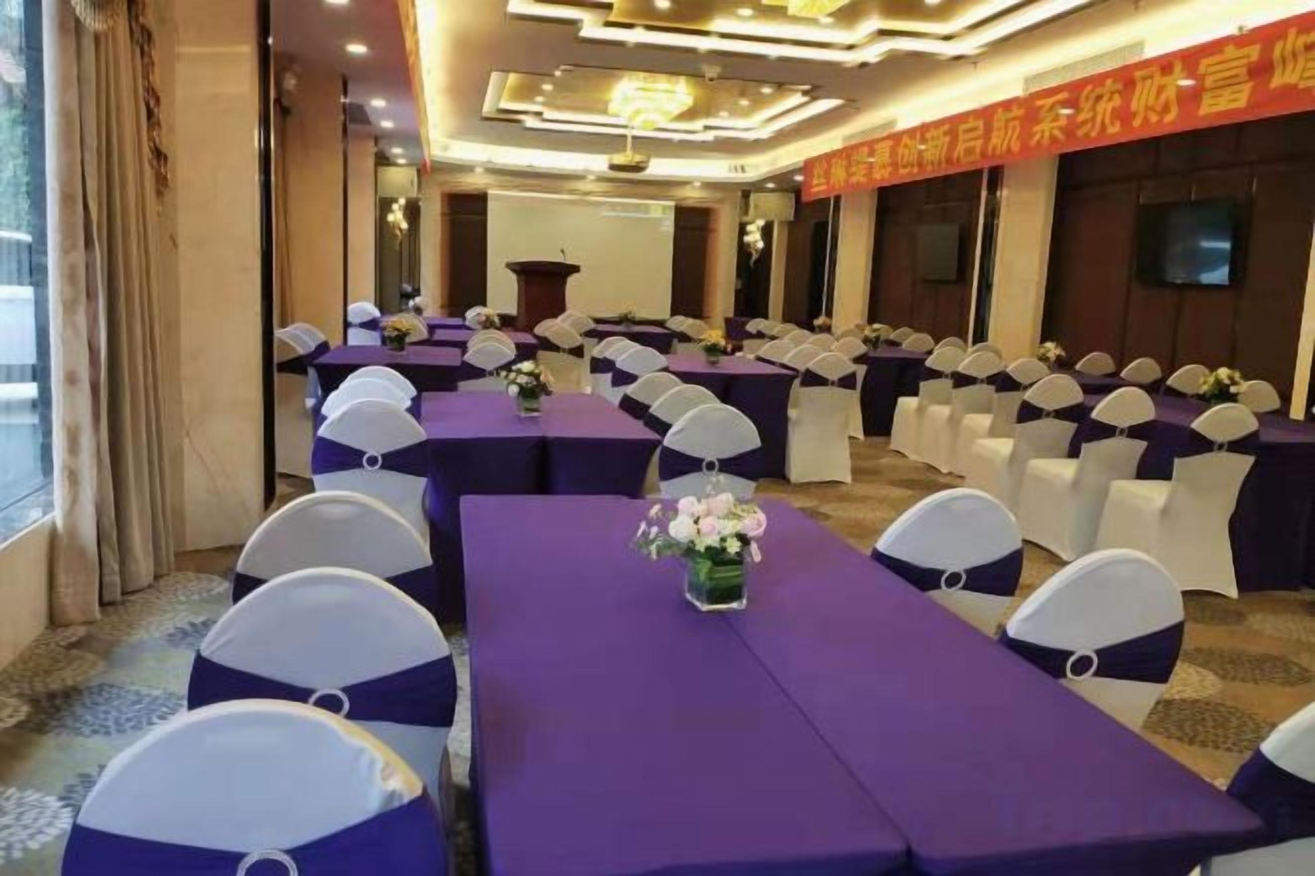 A conference room with tables and chairs, a podium, and a large window.