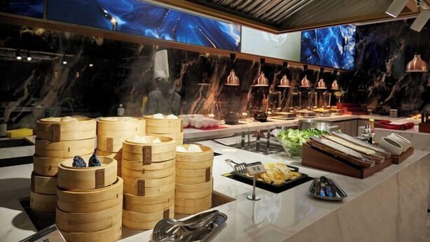 Un buffet proposant une variété de plats, notamment des petits pains cuits à la vapeur et un assortiment de mets présentés sur un comptoir.