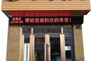A hotel entrance with a signboard displaying a time and a message in a foreign language. - Changchun Hotel (Ningbo)