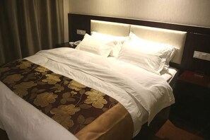 A hotel room with a bed, a nightstand, and a wall-mounted phone. - Changchun Hotel (Ningbo)