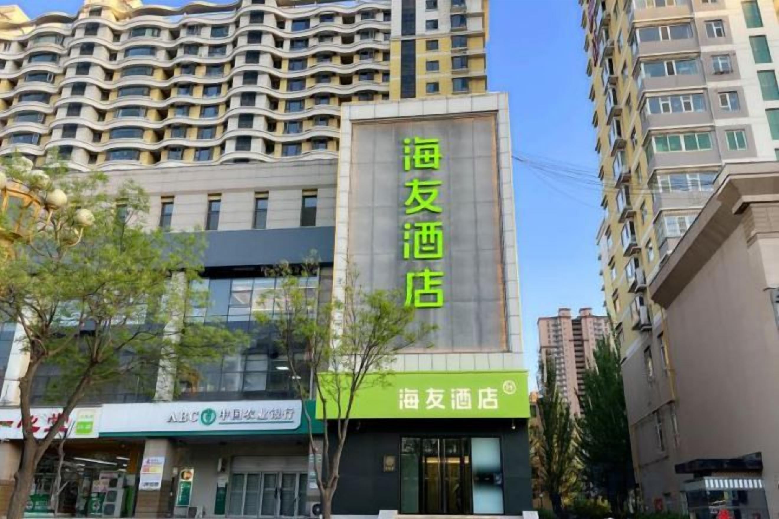 A hotel with a modern facade, large windows, and a prominent sign.