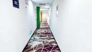 A hallway with a patterned floor, white walls, and doors on either side. - Days Inn Chain Hotel (Beijing Shangdi Xixiaokou Subway Station) (Beijing)
