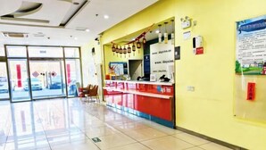 A reception area with a glass door entrance, a counter with a red and white color scheme, and a wall-mounted sign with a website URL. - Days Inn Chain Hotel (Beijing Shangdi Xixiaokou Subway Station) (Beijing)