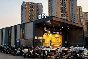 Un edificio con un cartello che indica un'area di parcheggio per biciclette e scooter, circondato da alti edifici residenziali.