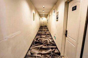 A hotel hallway with a patterned carpet, a door labeled '206', and a light fixture on the ceiling. - Days Inn Chain Hotel (Beijing Shangdi Xixiaokou Subway Station) (Beijing)