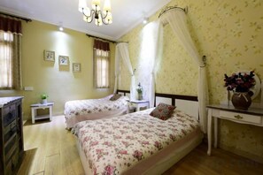 A bedroom with two beds, a nightstand, a dresser, and a bedside table with a lamp. - UUINN Villa (Xiamen)