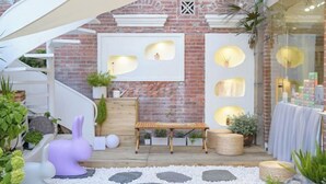 A cozy outdoor patio with a wooden bench, white pebbles, and potted plants. - UUINN Villa (Xiamen)