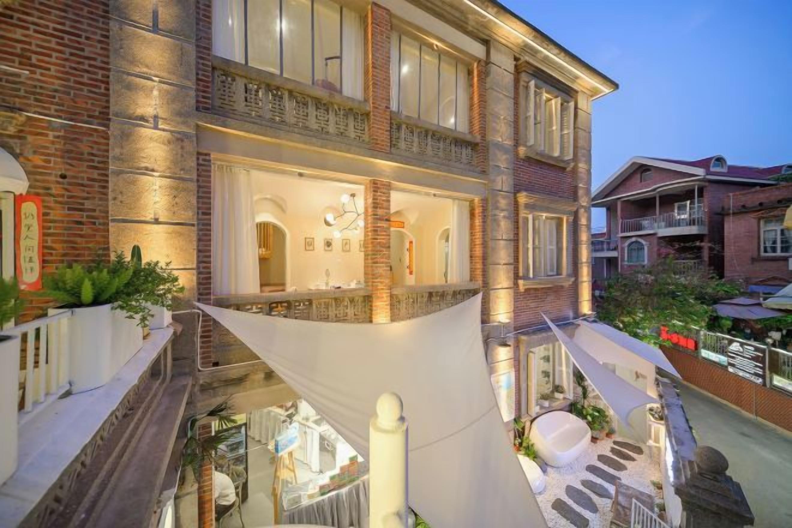 A multi-story building with a balcony, a staircase, and a pool area.