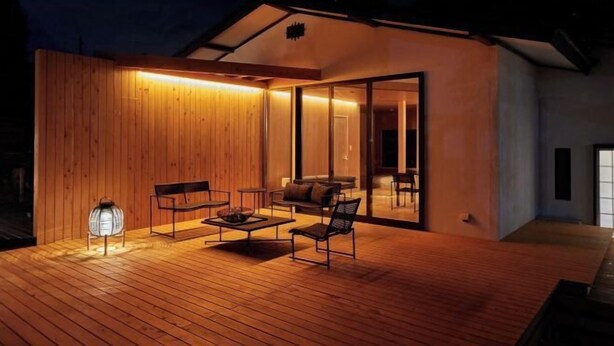 An outdoor wooden deck with a seating area, including a bench, chairs, and a table. - VOYAN RESORT Izu MADOKA (Ito)