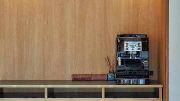 A wooden wall with a built-in shelf holding a coffee machine, a book, and a small vase.