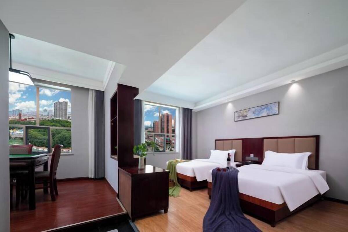 Camera d'albergo con due letti, una scrivania e vista sulla città.