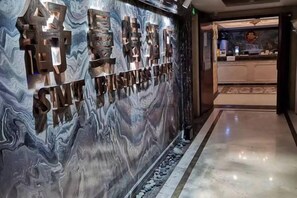 A reception area with a marble wall and a reception desk.