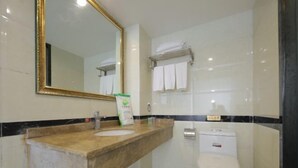 Une salle de bain avec un lavabo en marbre, des toilettes et un miroir avec un cadre doré.