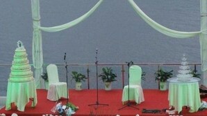 A stage with a green table, chairs, and a microphone stand. - Shell BAY Resort (Shenzhen)
