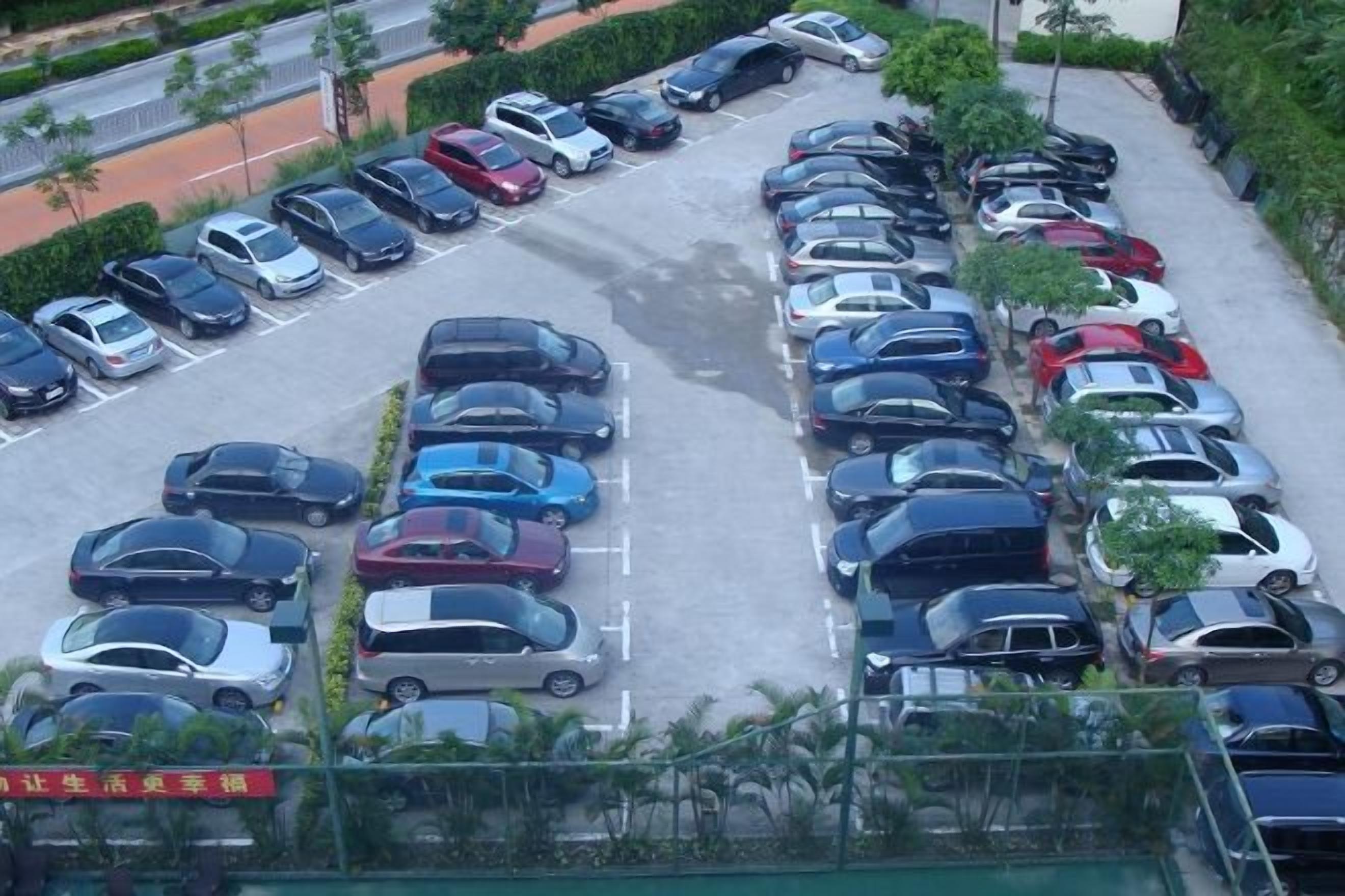 Ein Parkplatz mit mehreren Reihen geparkter Autos.