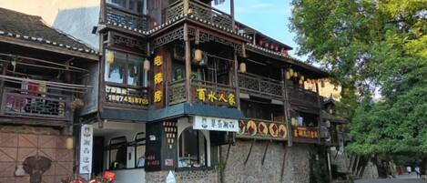 Un edificio tradicional de varios niveles, con balcones y señalización que indica un restaurante.