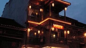 Un edificio tradicional con varios balcones y ventanas iluminadas.