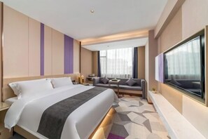 A hotel room with a large bed, a sofa, a TV, and a window with curtains. - Lavande Hotel (Chaozhou Fortune Center) (Chaozhou)