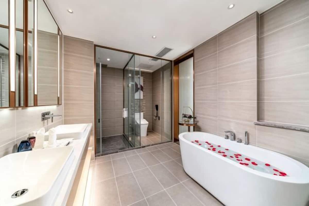 Un baño moderno con bañera, ducha y lavamanos separados.