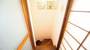 Una escalera estrecha con escalones y barandilla de madera.