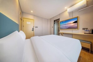 A hotel room with a bed, a desk, a chair, a TV, and a door. - Shanghai Wankai Collection Hotel (Shanghai)