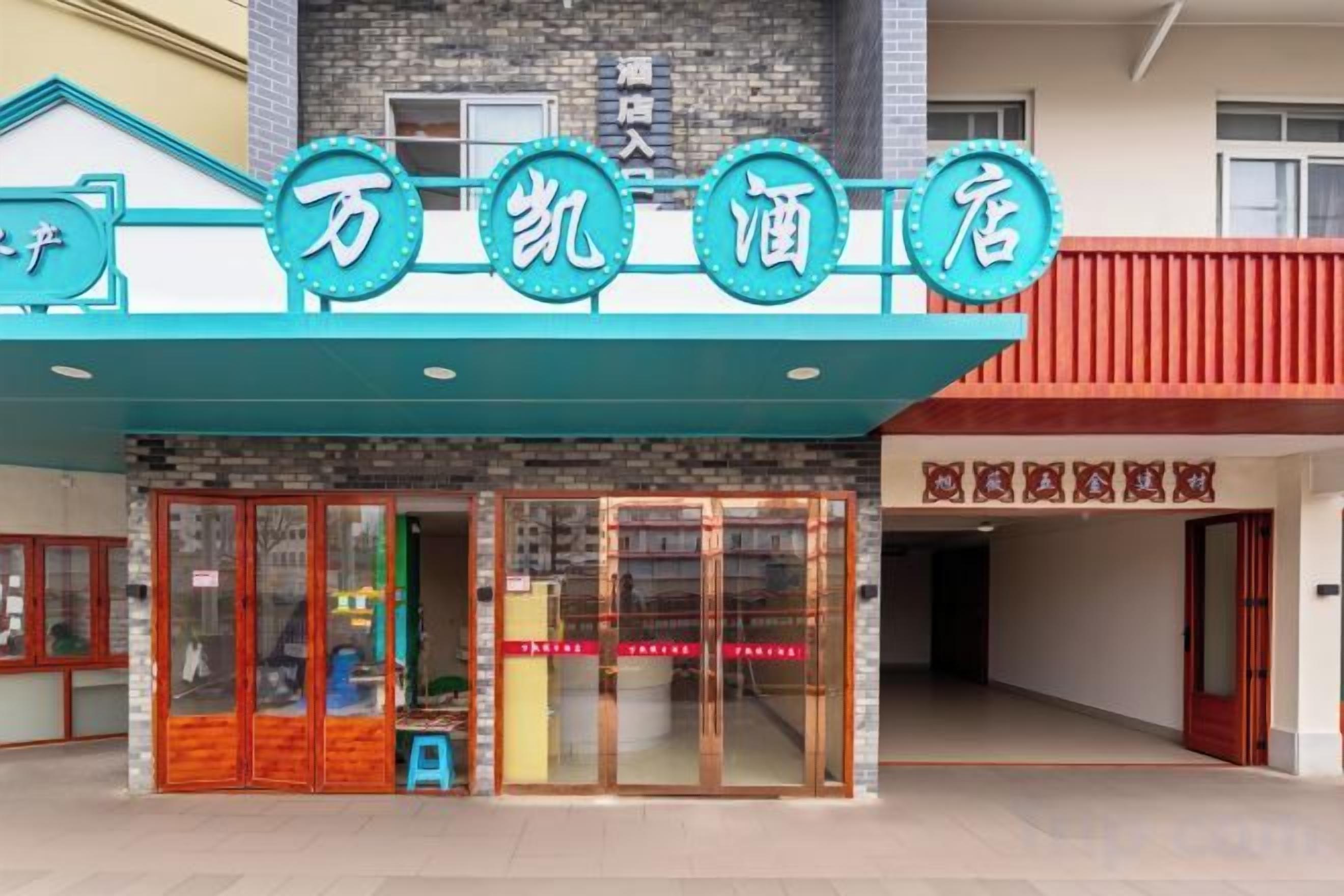 Entrada de hotel com toldo azul e placa com caracteres chineses.