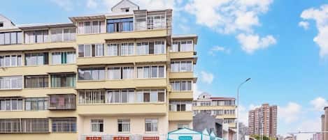 Un immeuble à plusieurs étages dont le rez-de-chaussée est aménagé en espace commercial, comprenant des boutiques et un cinéma.