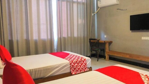 A hotel room with two beds, a desk, a chair, and a TV mounted on the wall. - Wentao Hostel (Shanghai)