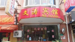 A hotel with a red sign and a phone number. - Wentao Hostel (Shanghai)