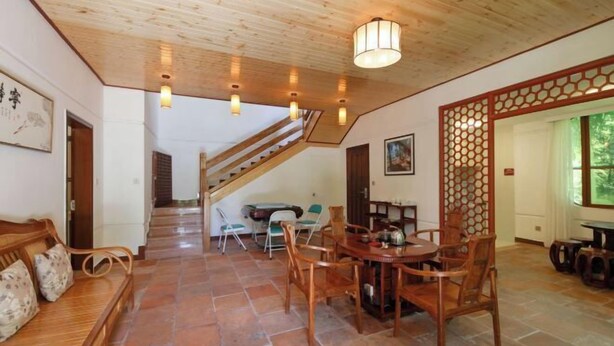 A wooden ceiling, a dining area with chairs and a table, a staircase, and a view through a window. - Enping Jinjiang Hotspring Hotel (Enping)