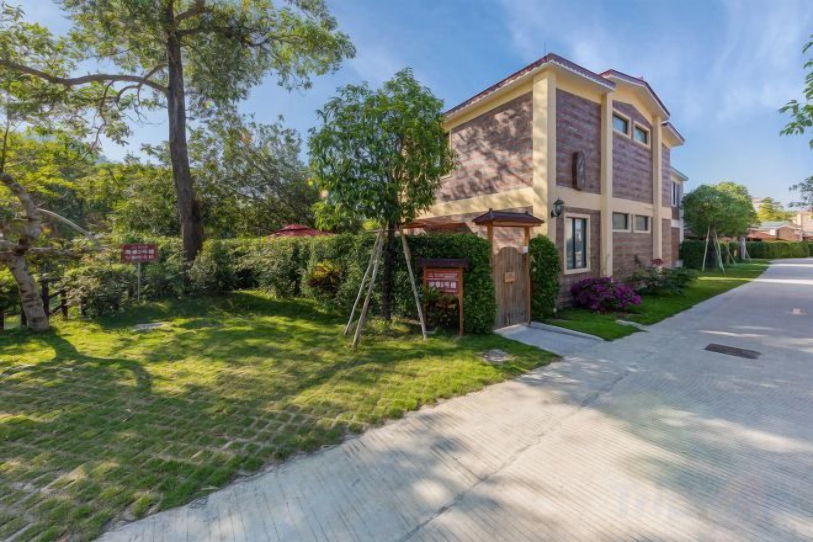 A two-story residential building with a brick facade, a front entrance, and a well-maintained lawn.