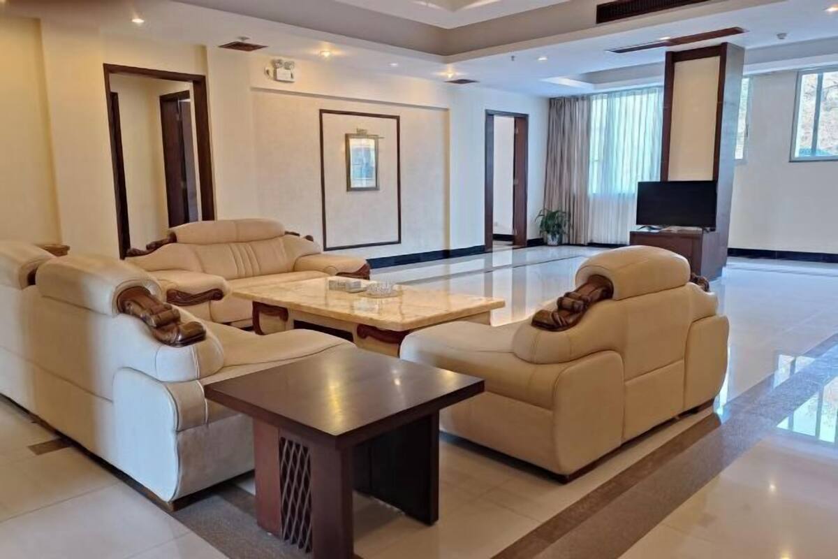 A spacious living area with a large sofa set, a coffee table, and a television.