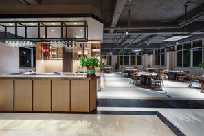 A modern interior with a central bar area, seating arrangements, and large windows. - Enping Jinjiang Hotspring Hotel (Enping)