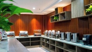 A buffet setup with multiple food dispensers and a long counter. - Jinse Yangguang Motel (Kuqa)