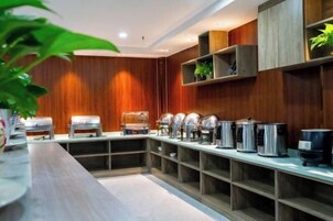Montaje de bufé con múltiples dispensadores de comida y una larga barra.