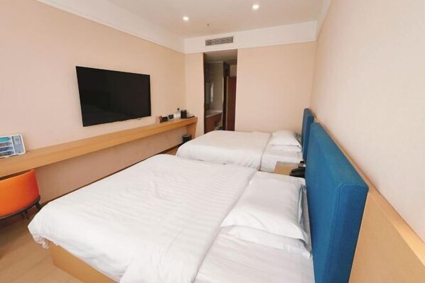 A hotel room with two beds, a TV, and a small desk with a chair. - Jinse Yangguang Motel (Kuqa)