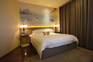A hotel room with a large bed, two bedside tables with lamps, a wall mural, and a view of the outdoors.