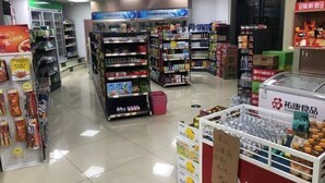 A supermarket aisle with various products on shelves and a refrigerated display. - Jiujiantang Yijin Hotel (Hangzhou)
