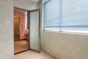 A bathroom with a toilet, sink, and towel rack. - Dongguan Tian Boutique Hotel (Dongguan)