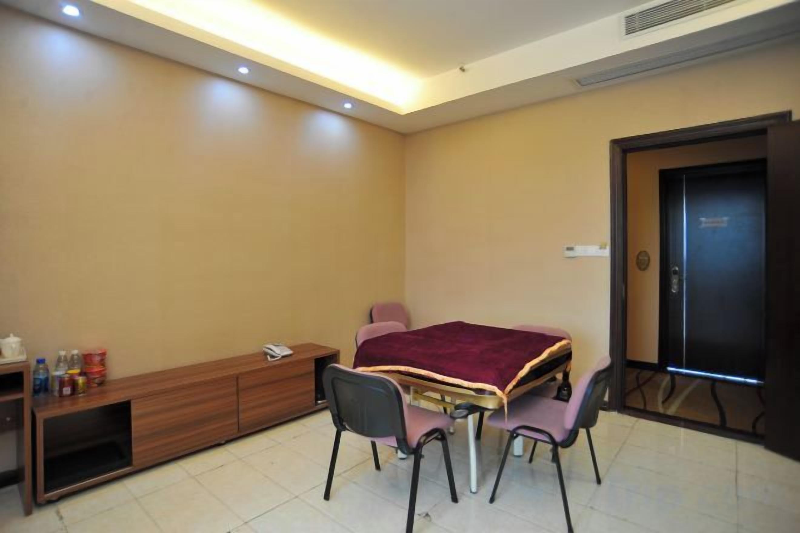 A room with a bed, a desk, and two chairs.