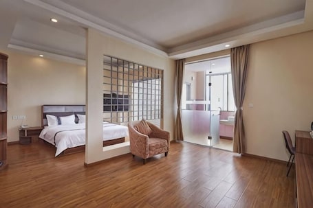A hotel room with a bed, a chair, a desk, and a large window.. Dongguan Tian Boutique Hotel