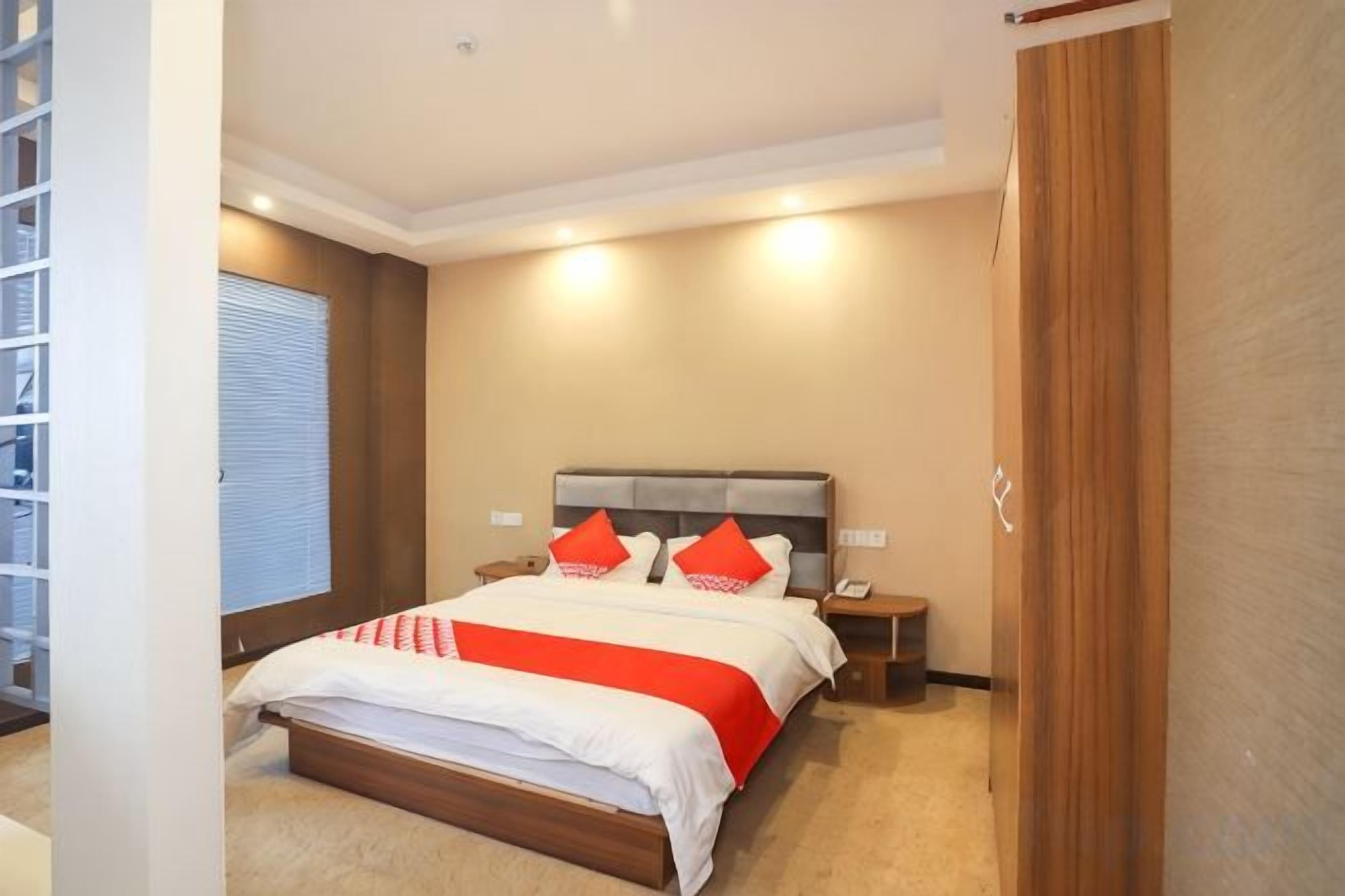 Un dormitorio con cama, mesitas de noche y un velador.