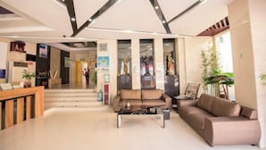 Eine moderne Lobby mit einer Rezeption, Sofas und einer Treppe zu weiteren Bereichen.