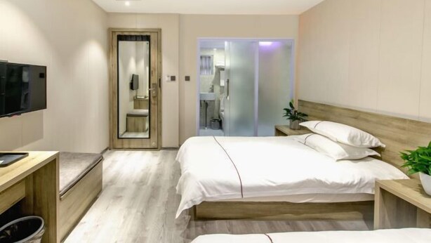 Ein Hotelzimmer mit Bett, Nachttisch, Fernseher und Spiegel.