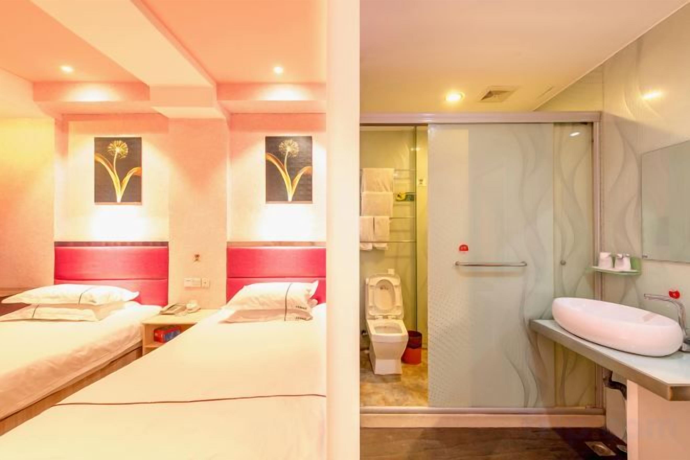 A hotel room with two beds, a shower, and a sink.