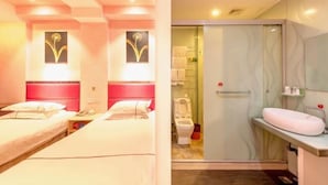 Ein Hotelzimmer mit zwei Betten, einer Dusche und einem Badezimmer mit Waschbecken und Spiegel.