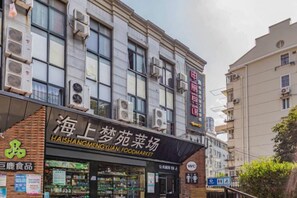 Un mercado de alimentos con un escaparate que dice 'HAISHANGMENGYUAN FOODMARKET' y un letrero de 'WC' visible.