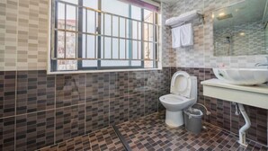 A bathroom with a tiled floor, a toilet, a sink with a mirror, and a window with bars. - Shenli Hostel (Shanghai)