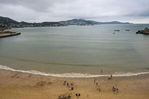 A coastal beach with a sandy shore and calm waters. - Haiyi Jiage Inn (Shengsi)
